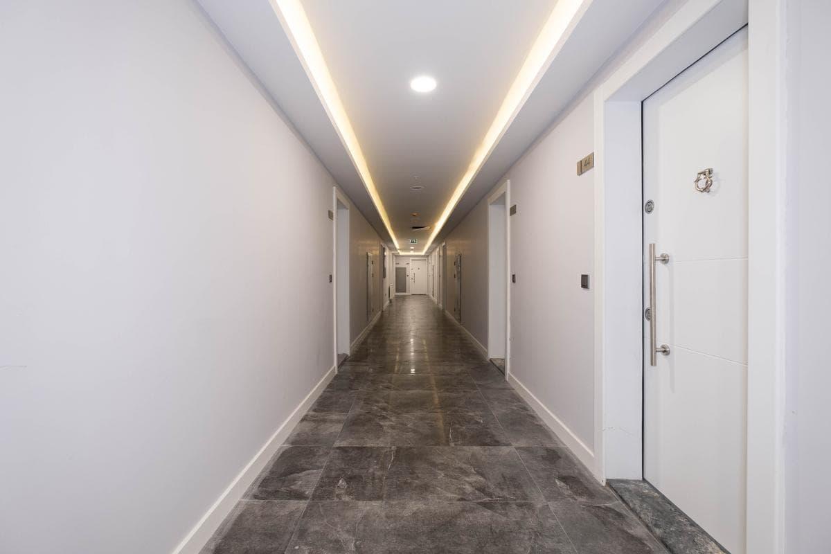 Freshly painted interior apartment corridor with clean white walls and unit entry doors